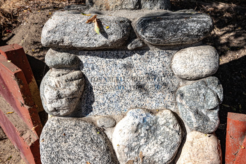 Hard to read stone sign that says Sunnynook Park.